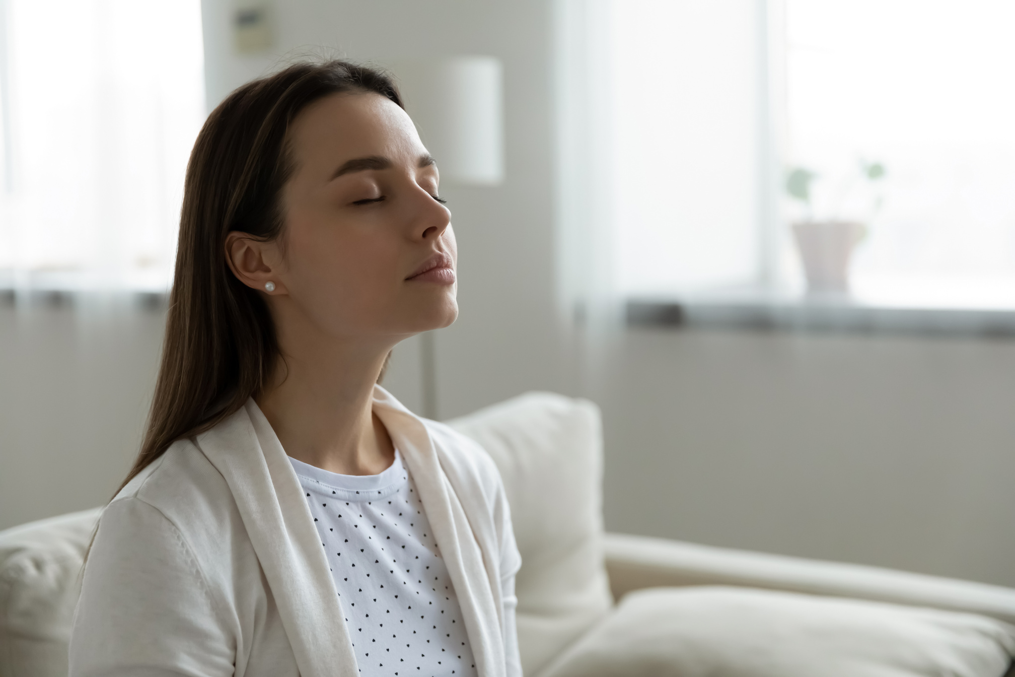 Calm woman resting closed eyes breathing fresh humidified air